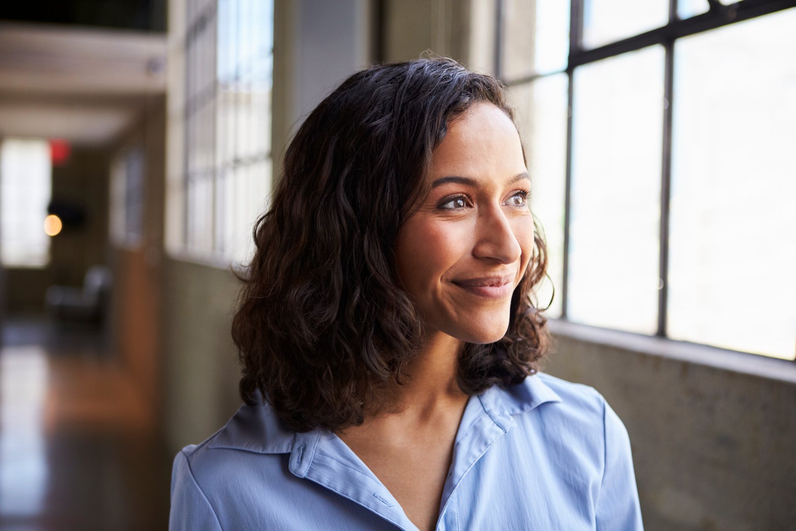 Smiling young mixed race businesswoman looking away